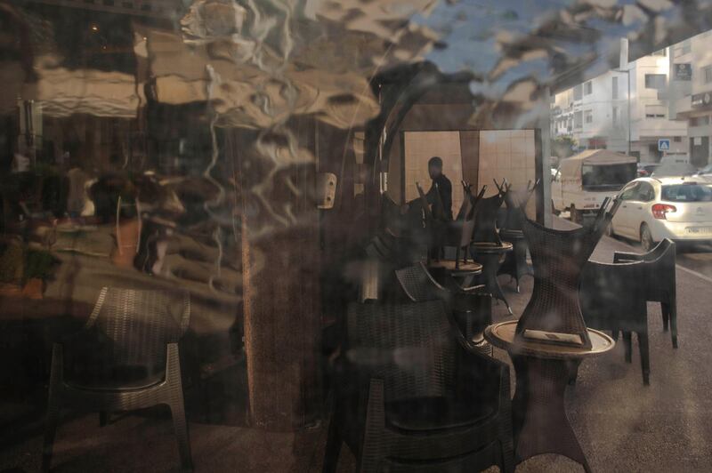A worker closes down a coffee shop after the Moroccan government announced further restrictions to avoid the spread of Covid-19. AP Photo