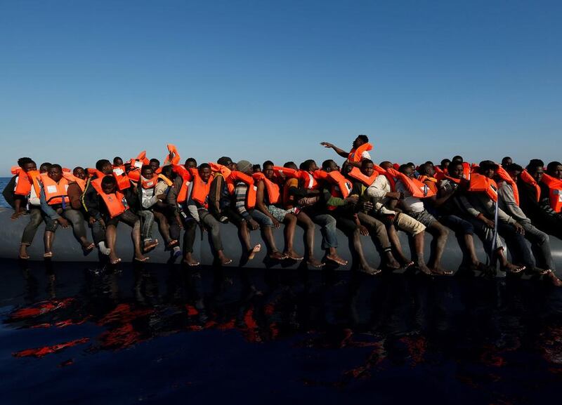 Migrants on a rubber dinghy await rescue by the Malta-based NGO Migrant Offshore Aid Station in the central Mediterranean in international waters about 15 nautical miles off the coast of Zawiya in Libya.   Darrin Zammit Lupi / Reuters