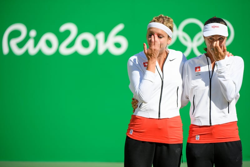 epa06291012 FILE --- Silver medalist Martina Hingis, right, and Timea Bacsinszky, left, of Switzerland react on the podium after the women's doubles gold medal match against Ekaterina Makarova and Elena Vesnina of Russia at the Olympic Tennis Center in Rio de Janeiro, Brazil, at the Rio 2016 Olympic Summer Games, pictured on Sunday, August 14, 2016. Martina Hingis has confirmed on Thursday, 26 October 2017, she will retire from tennis following the conclusion of the WTA Finals in Singapore.  EPA/LAURENT GILLIERON EDITORIAL USE ONLY