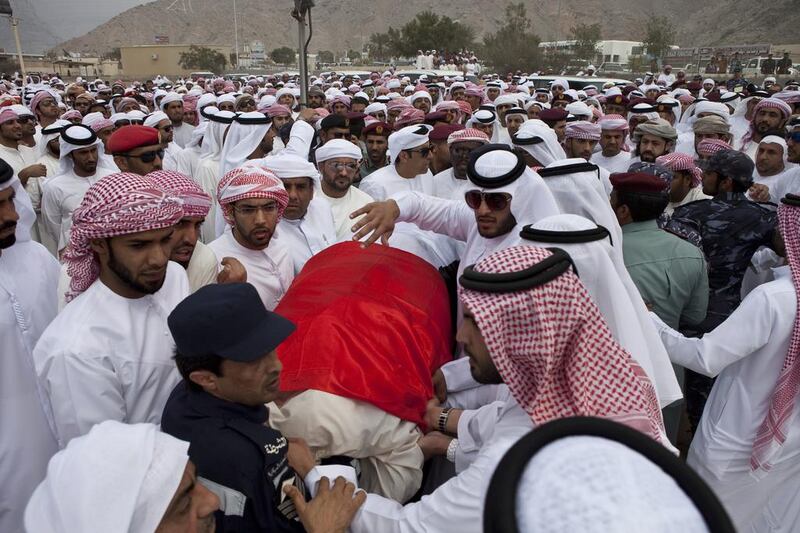 Mourners carry the body of Tariq Al Shehi to his final resting place at Shaam cemetery. Antonie Robertson/The National