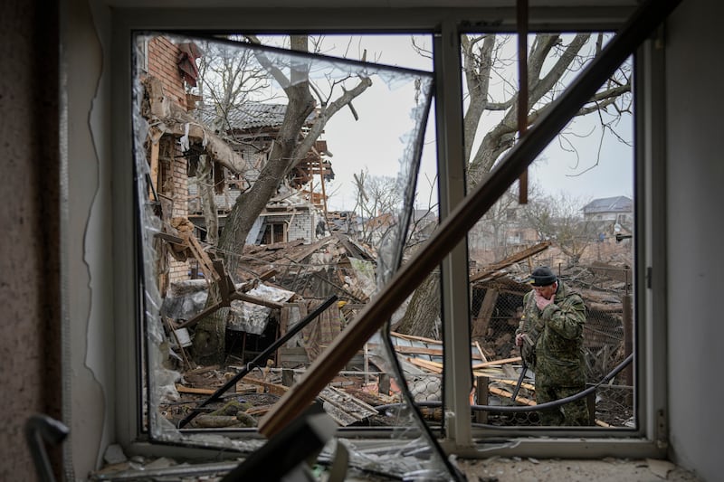 A Ukrainian civil defence member in the garden of a house damaged by a Russian airstrike. AP Photo