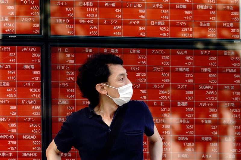 A man stands in front of an electronic stock board showing Japan's Nikkei 225 index at a securities firm in Tokyo Tuesday, June 16, 2020. Asian shares rose Tuesday, cheered by fresh moves by the U.S. Federal Reserve to support markets battered by the coronavirus pandemic.(AP Photo/Eugene Hoshiko)