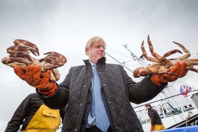 STROMNESS, SCOTLAND - JULY 23: British Prime Minister Boris Johnson holds crabs caught on the Carvela at Stromness Harbour on July 23, 2020 in Stromness, Scotland. This week marks one year as U.K. Prime Minister for Conservative Party leader Boris Johnson. Today he is visiting businesses in the Orkney Islands in Scotland to reaffirm his commitment to supporting all parts of the UK through the Coronavirus pandemic. Later he will visit a military base in Moray to thank Military personnel for their service. (Photo by Robert Perry - WPA Pool/Getty Images)