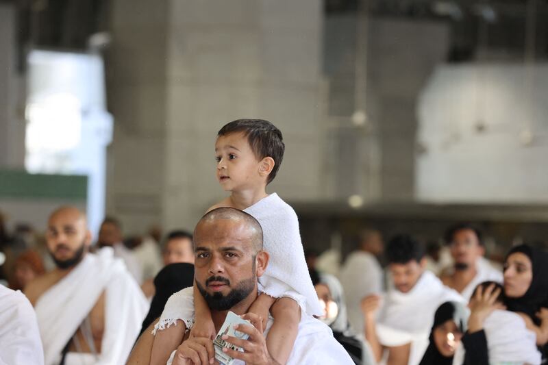A man carries a child at the Grand Mosque in Makkah