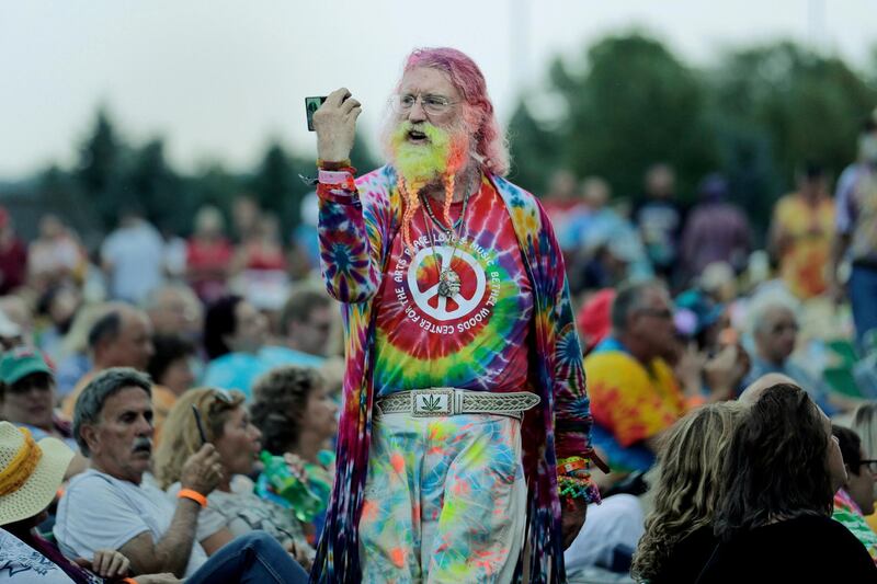 A man walks through the crowd during an Arlo Guthrie concert at a Woodstock 50th anniversary event in Bethel, New York.   AP