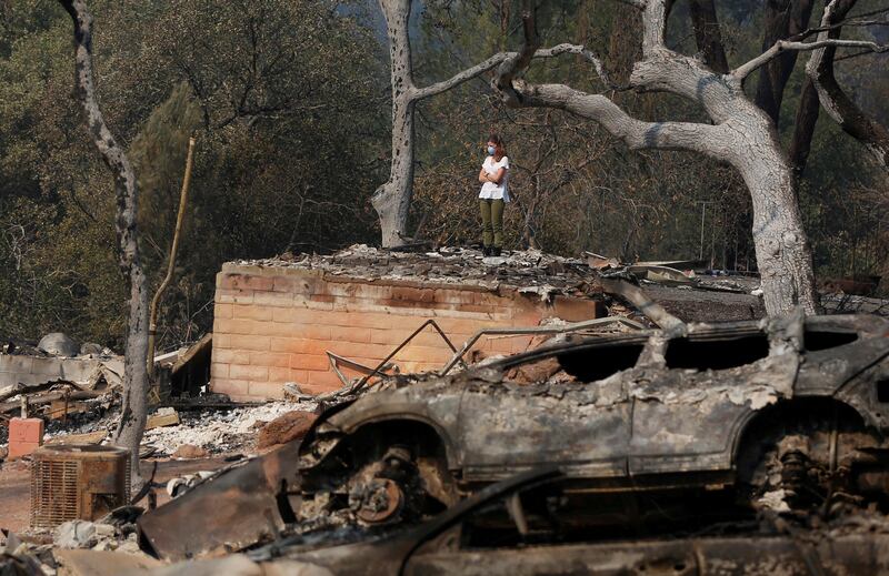 Pamela Garibaldi looks over burned remains of her parents home destroyed by wildfire in Napa, California, U.S., October 13, 2017. REUTERS/Jim Urquhart     TPX IMAGES OF THE DAY