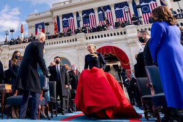 Lady Gaga, centre, arrives to perform the National Anthem as President Joe Biden, left, and Vice President Kamala Harris, right, watch. EPA