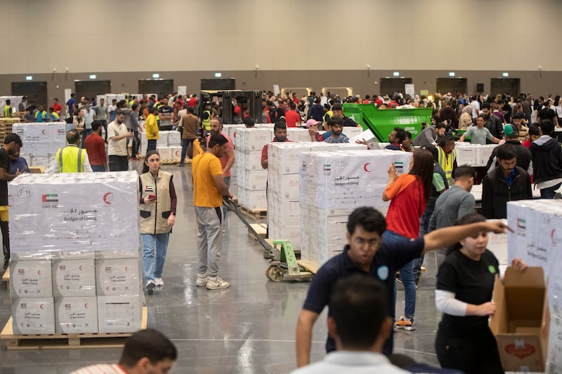 Volunteers pack food, blankets and other essential goods at the Dubai Exhibition Centre, at Expo City