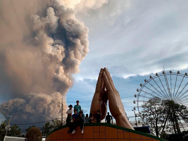 People watch as the Taal volcano spews ash and smoke during an eruption in Tagaytay, Cavite province south of Manila, Philippines. AP Photo