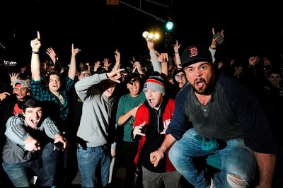 Fans celebrate the Red Sox World Series victory over the LA Dodgers at Kenmore Square in Boston, Massachusetts, late on October 28, 2018.  The Boston Red Sox romped to their ninth World Series crown on October 28, pounding the Los Angeles Dodgers 5-1 with a ruthless display of hitting to clinch the Major League Baseball championship with two games to spare. / AFP / Joseph PREZIOSO
