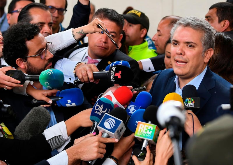 Colombian presidential candidate Ivan Duque, for the Democratic Centre party, speaks to the press at a polling station in Bogota during the first round of the presidential election in Colombia on May 27, 2018. Voters went to the polls Sunday to choose a new president of Colombia in a divisive election that is likely to weigh heavily on the future of the government's fragile peace deal with the former rebel movement FARC. / AFP / Luis ACOSTA
