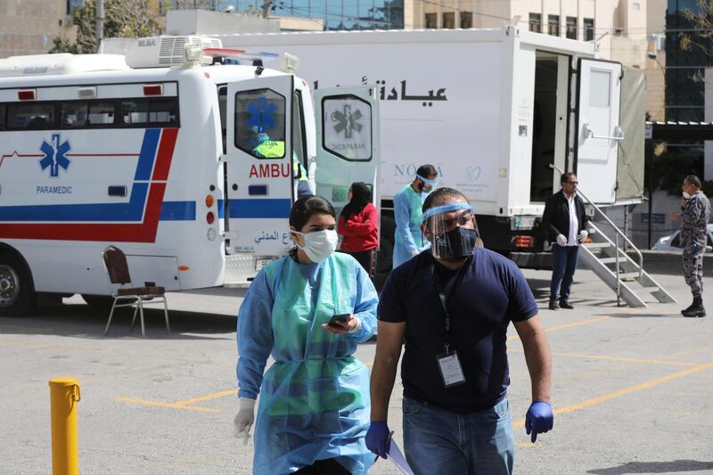 Jordanian doctors walk next to the mobile clinics that are operated as part of initiative that was launched with the aim of providing Jordanians with field medical services, amid concerns over the spread of the coronavirus, in Amman, Jordan. Reuters