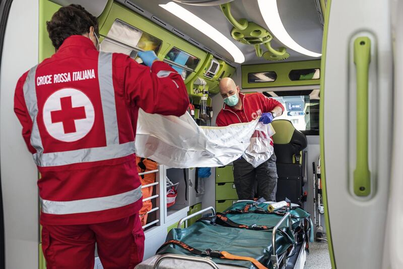 BERGAMO, ITALY - APRIL 4: (EDITORIAL USE ONLY) Italian Red Cross members check and prepare the ambulance before their shift on April 4, 2020 in Bergamo, Italy. The number of new COVID-19 cases appears to be decreasing in Italy, including in the province of Bergamo, one of its hardest-hit areas. But as the infection rate slows, life is still far from normal. A local newspaper, the Eco di Bergamo, estimates that the province has lost roughly 4,800 people to coronavirus - almost twice an official tally that only counts hospital deaths - and everyone here knows someone who's fallen ill:  a neighbor, a family member, a relative, a friend or an acquaintance. The Italian Red Cross, which runs an ambulance service here, continues to field constant calls for help. With only a small portion of its 600-person volunteer crew and 38 paid staff able to report for duty, those who remain work shifts of up to 20 hours long. (Photo by Marco Di Lauro/Getty Images)