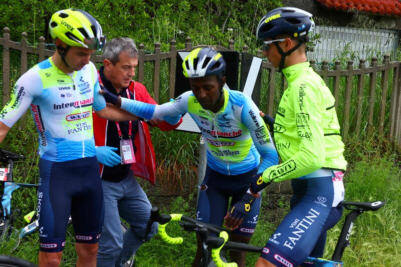 Team Intermarche's Eritrean rider Biniam Girmay, centre, is helped by teammates after his crash. AFP