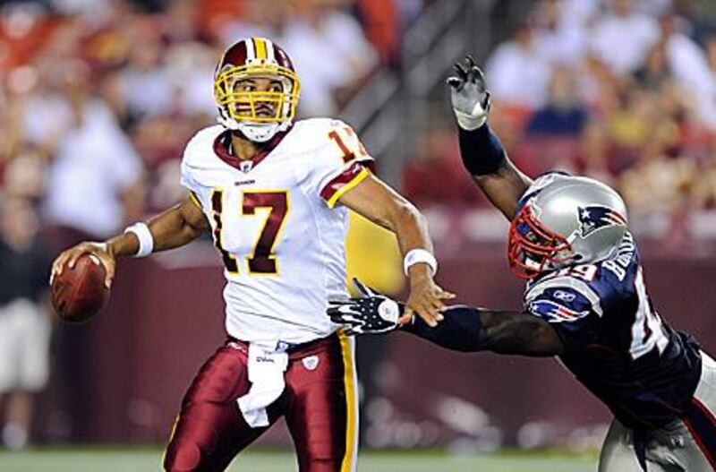 The Redskins' Jason Campbell, left, is hit during a pre-season game by Derrick Burgess of the New England Patriots at FedExField in Landover, Maryland.