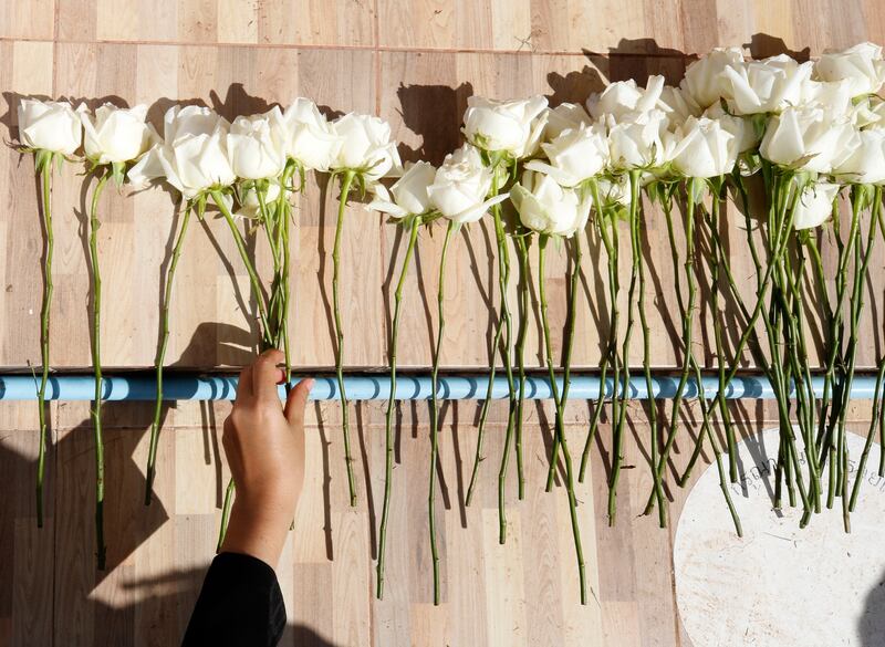 A relative of the deceased lays a flower. EPA