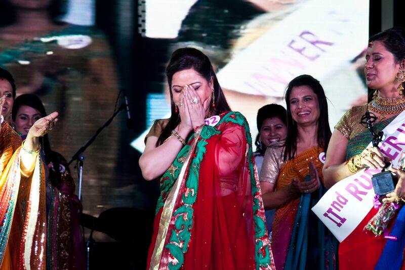 Jyoti Nagpal (#2, in red/green), aged 35, reacts as she walks to the front to receive her winner's award at the inaugural AAS Housewives Awards 2012 on 19th May 2012 in New Delhi, India. Out of 12 selected semi-finalists, 6 finalists are chosen based on a question and answer session on stage, and other criteria such as poise. The winner, and 1st and 2nd runner-ups are Jyoti Nagpal (#2), Nisha Sharma (#7) and Seema Sharma (#4)respectively. The awards also served as a platform for Cervical Cancer Awareness. Photo by Suzanne Lee for The National