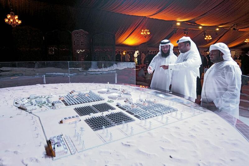 Officials and delegates from Dewa look at a model that represents the entire proposed Mohammed bin Rashid Al Maktoum Solar Park. Antonie Robertson / The National