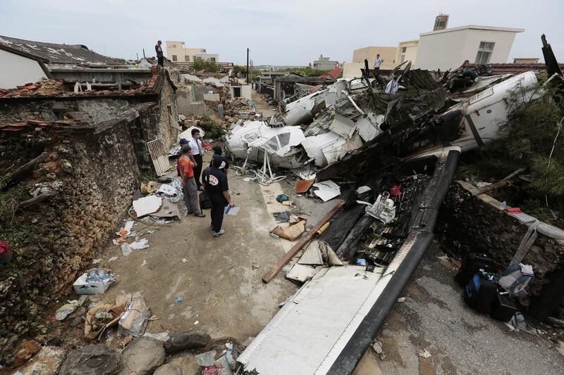 Investigators search through the crash site where TransAsia Airways flight GE222 crashed on July 23, 2014 near the airport at Magong in Penghu Island, Taiwan. The crash killed 48 of the 58 people on board when it went down amid torrential rains. Ashley Pon/Getty Images