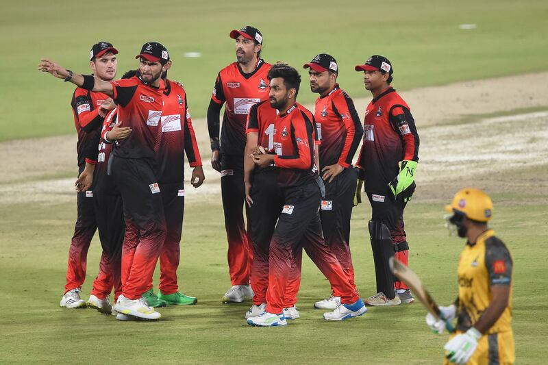 Lahore Qalandars players, in their away kit, celebrate after the dismissal of Peshawar Zalmi's Hussain Talat in their PSL match at the National Cricket Stadium in Karachi on February 2, 2022. AFP