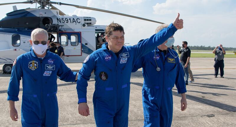 NASA astronaut Robert Behnken gives a thumbs up to onlookers as he boards a plane at Naval Air Station Pensacola. REUTERS-