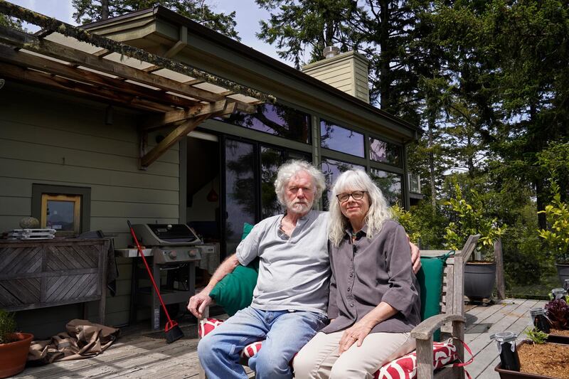 Gordon Bennett and his wife Kate Carolan sit outside their home in Inverness, California. The couple, who were victims of Bernard Madoff and forced to sell their home, now rent it back from someone they know who purchased it. AP