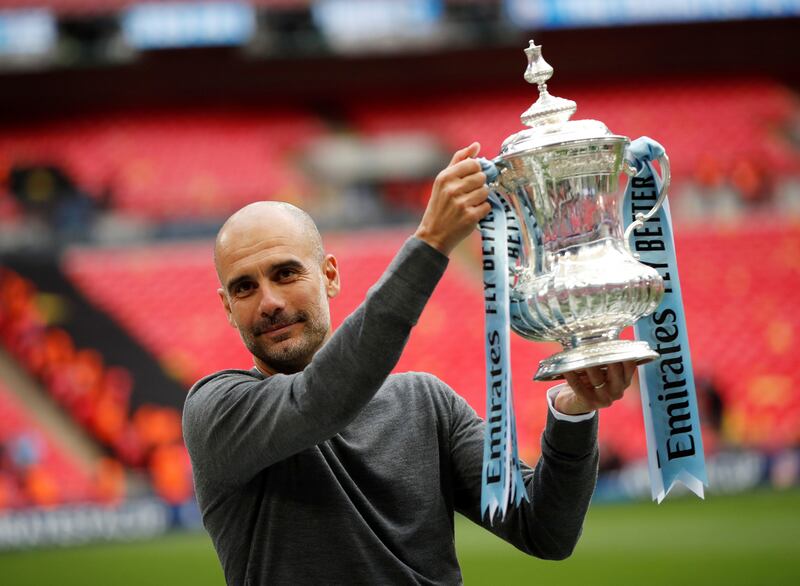 Manchester City manager Pep Guardiola poses with the trophy as he celebrates after winning the FA Cup at Wembley in 2019. Reuters