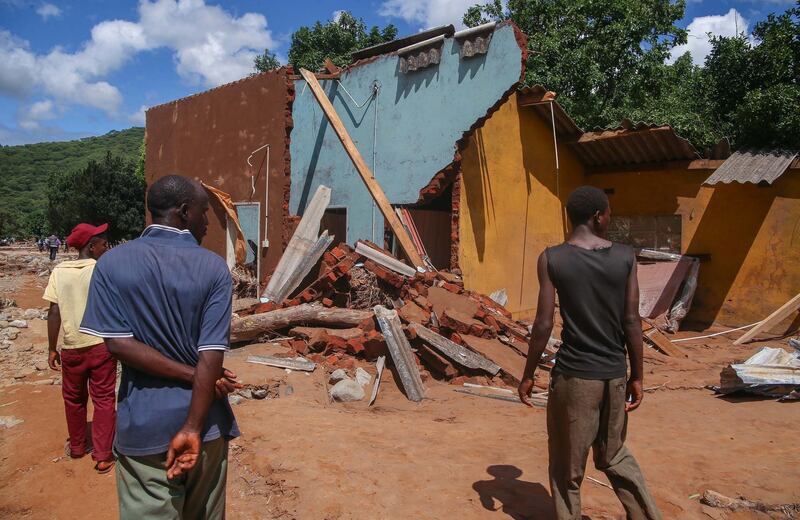 People survey a collapsed building in Chipinge, Zimbabwe. Getty Images