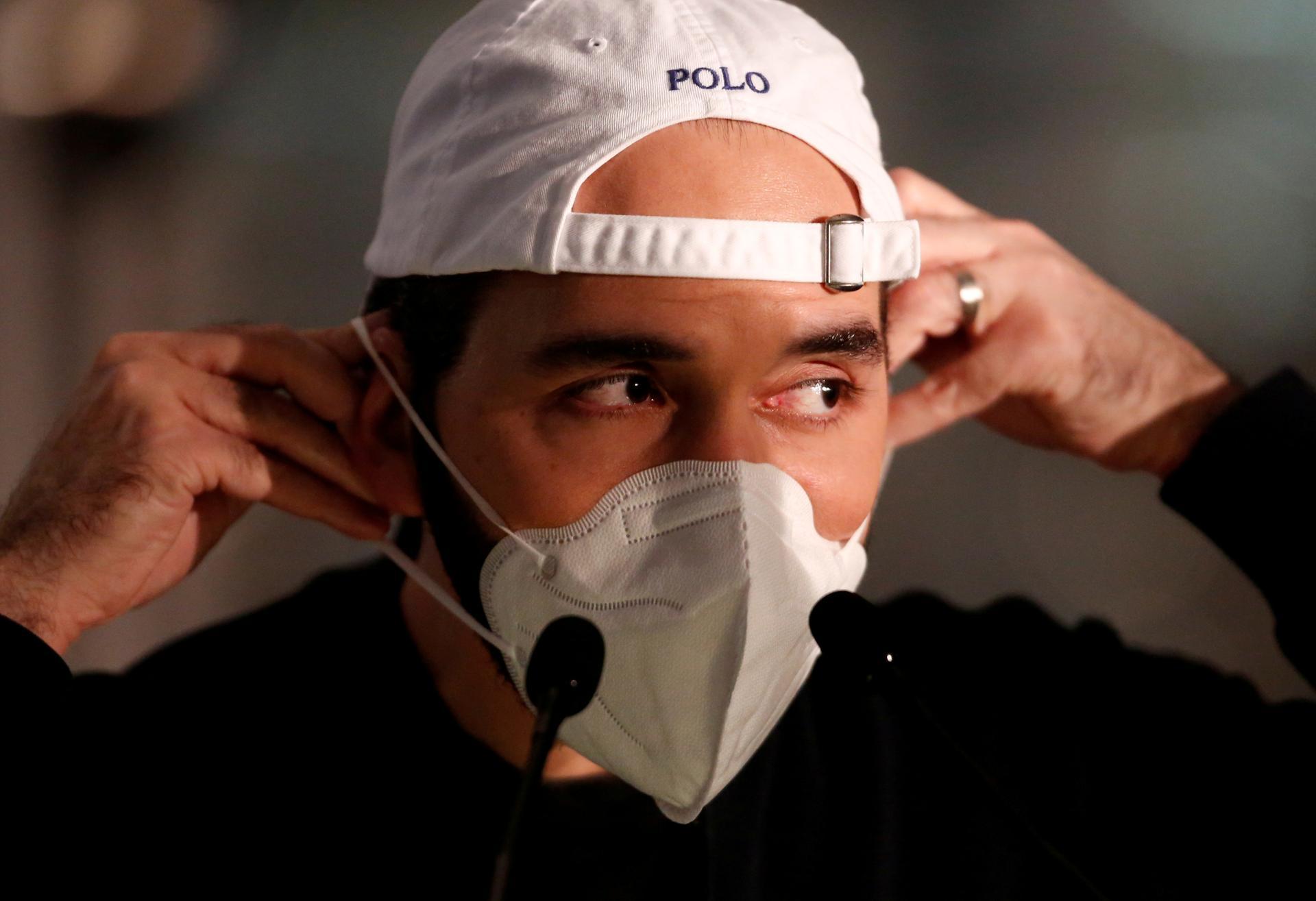 El Salvador President Nayib Bukele puts on a face mask after a news conference during a nationwide quarantine as El Salvador's government undertakes steadily stricter measures to prevent the spread of the coronavirus disease (COVID-19), in Ilopango, El Salvador. REUTERS