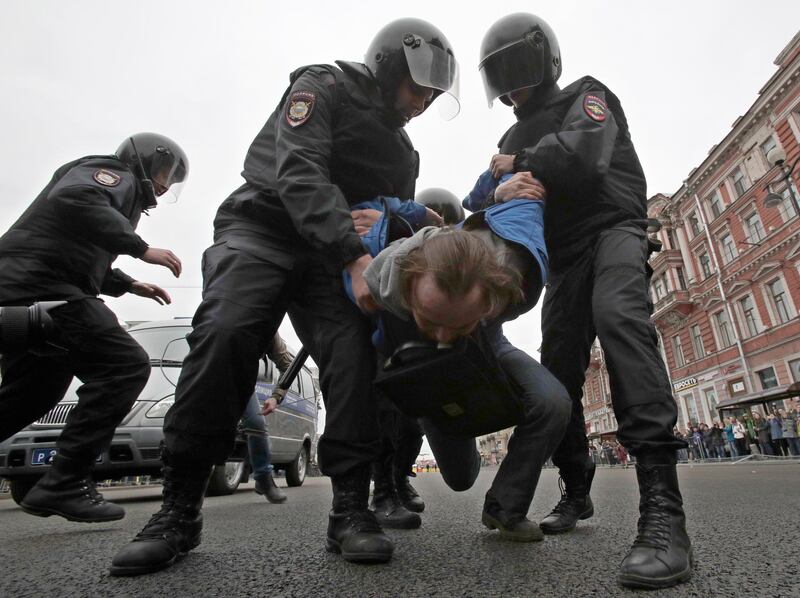 Russian police detain a protester at a demonstration against President Vladimir Putin in St.Petersburg, Russia, Saturday, May 5, 2018. A group that monitors political repression in Russia says more than 350 people have been arrested in a day of nationwide protests against the upcoming inauguration of Vladimir Putin for a new six-year term as president. (AP Photo/Dmitri Lovetsky)