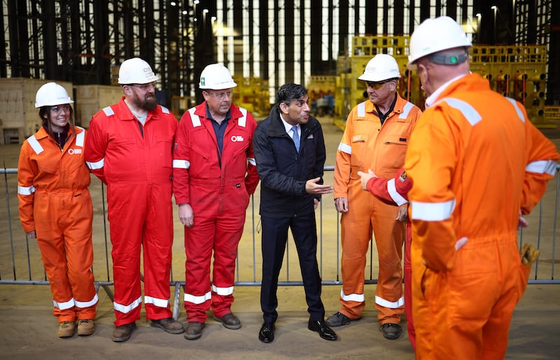 Mr Sunak speaks with members of staff at the Global Energy Group facility at the Port of Nigg in north-east Scotland. AFP