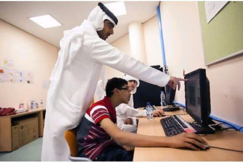 Mohamed Mohsan, 14, is helped by his teacher Mohamed Al Marzouqi while working on Game Maker at Al Marwah School.