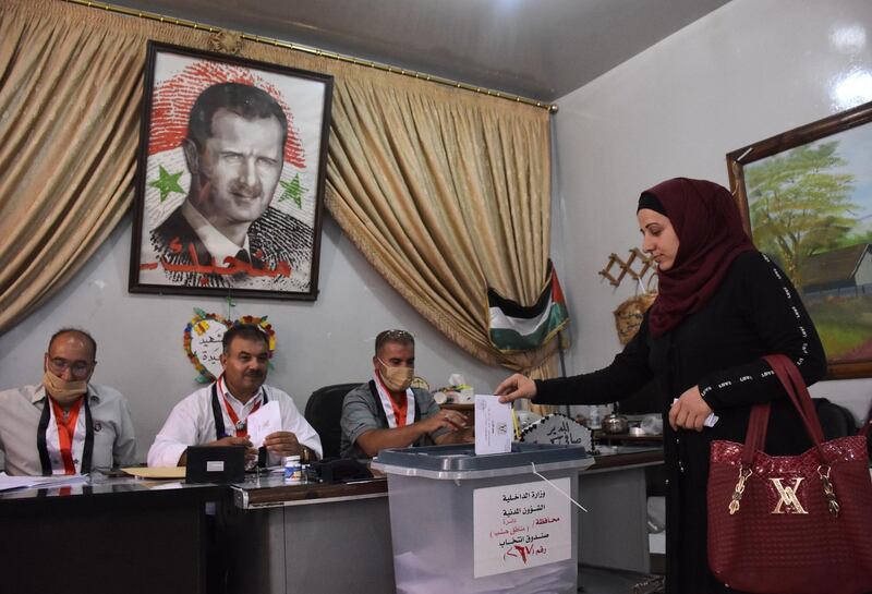 A Syrian woman casts her ballot at a polling station in the Nubl neighbourhood of Aleppo on July 19, 2020, during the parliamentary elections.  Syrians vote today to elect a new parliament as the Damascus government grapples with international sanctions and a crumbling economy after retaking large parts of the war-torn country. / AFP / -
