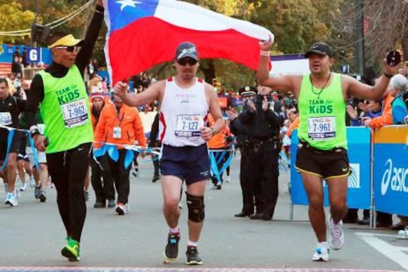 NEW YORK - NOVEMBER 07: Edison Pena (C), one of the recently rescued Chilean miners, crosses the finish line to complete the 41st ING New York City Marathon in Central Park on November 7, 2010 in New York City.   Andrew Burton/Getty Images/AFP