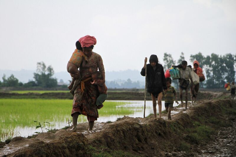 Rohingya refugees from Rakhine state in Myanmar walk along a path near Teknaf in Bangladesh on September 23, 2017.
Around 400 people -- most of them Rohingya Muslims -- have died in communal violence searing through Myanmar's Rakhine state, the army chief's office said September 1, with tens of thousands forced to flee across the border into Bangladesh. A further 20,000 Rohingya have massed along the Bangladeshi frontier, while scores of desperate people have drowned attempting to cross the Naf, a border river, in makeshift boats.
 / AFP PHOTO / R. ASAD