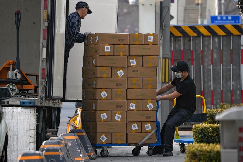 Workers unload boxes in Beijing. Oil demand is expected to surge to record levels this year, driven by China’s recovery. AP