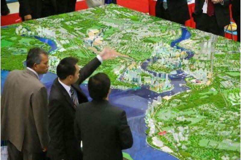 Visitors to the Malaysia-China Business Forum at the Persada Johor International Convention Centre view a large model of the Danga Bay area of Johor's Iskandar Development Region, in Johor Bahru, Malaysia, on Thursday, July 5, 2007. Malaysia is attempting to spur the development of southern Johor state by improving the region's infrastructure. The nation is expecting $40 billion of direct foreign investment over seven years for the project, named the Iskandar Development Region. Photographer: Jonathan Drake/Bloomberg News