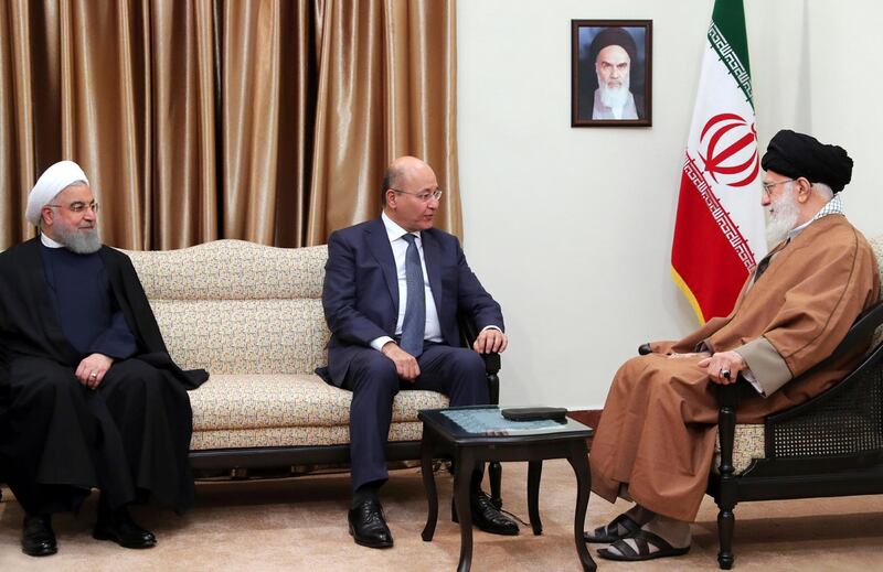 In this picture released by an official website of the office of the Iranian supreme leader, Iraqi President Barham Salih, center, speaks with Iranian Supreme Leader Ayatollah Ali Khamenei, right, as his Iranian counterpart Hassan Rouhani listens during their meeting in Tehran, Iran, Saturday, Nov. 17, 2018. Salih began a visit to Iran on Saturday, where he pledged to improve relations less than two weeks after the United States restored oil sanctions that had been lifted under the 2015 nuclear deal. A portrait of the Iranian revolutionary founder Ayatollah Khomeini hangs on the wall. (Office of the Iranian Supreme Leader via AP)
