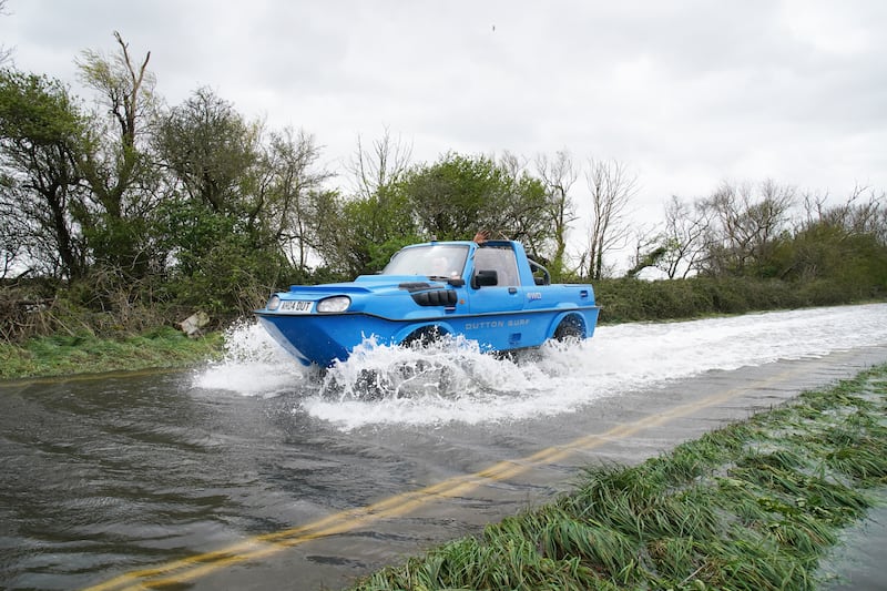 A vehicle ploughs through a flooded road in Littlehampton, West Sussex, after the Arun river burst its banks. PA