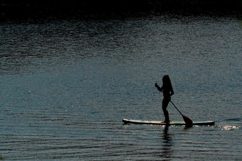 A woman uses a stand up paddle (SUP) on the Old Danube (Alte Donnau), a subsidiary of the Danube river, in Vienna, Austria. AFP
