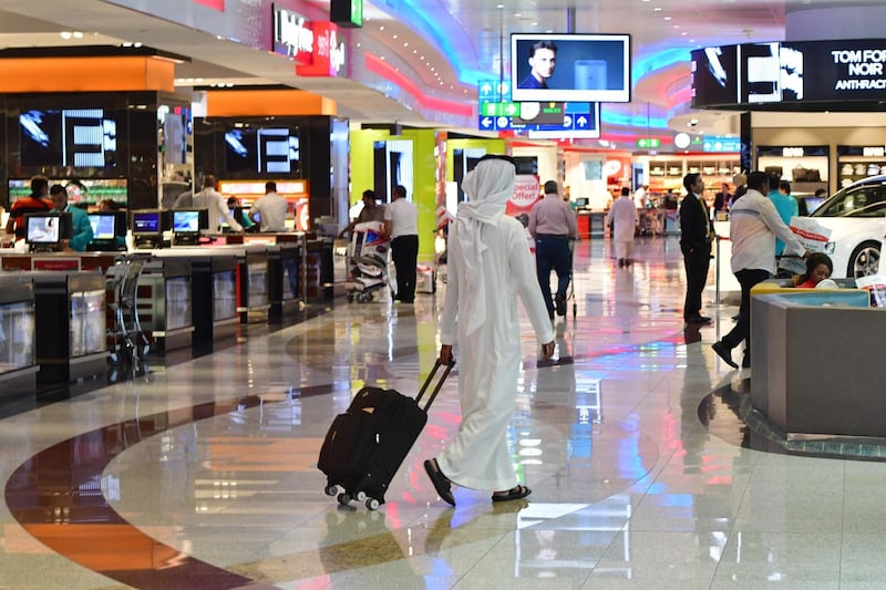 A picture take on September 14, 2017 shows people walking at Dubai's International Airport . / AFP PHOTO / GIUSEPPE CACACE