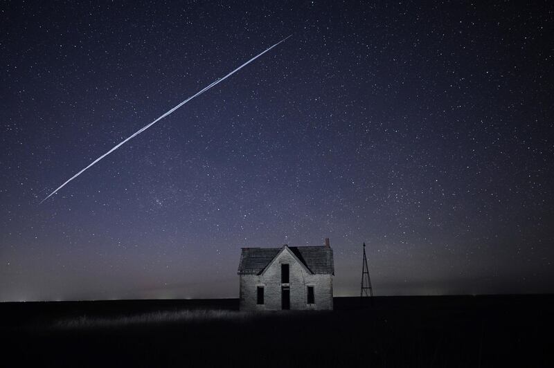 A long-exposure image shows a string of SpaceX StarLink satellites pass over an old house near Florence, Kansas, US. AP Photo