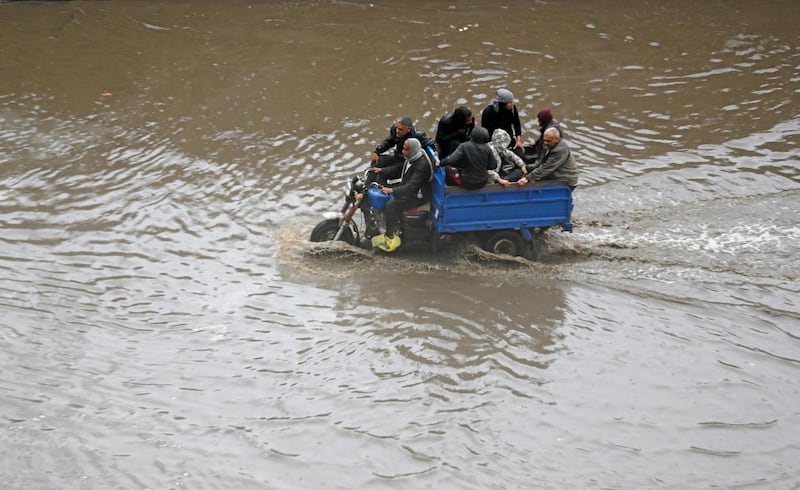 People ride a motorcycle during a thunderstorm and heavy rains in downtown Cairo. Reuters