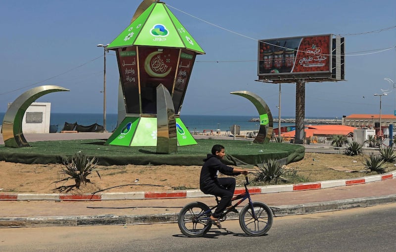 A Palestinian boy rides past a giant traditional lantern known as fanous in Gaza city. AFP