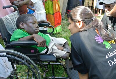 AMOLATAR, UGANDA, Wednesday, Nov. 29, 2017 // Dubai Cares program manager Mada Al Suwaidi, right, meets with a child at Alemere Primary School in Northern Uganda. Dubai Cares recently awarded Cheshire Services Uganda US$762,000 (Dh2,798,917) to help enroll 500 children with disabilities in 10 mainstream primary schools across a Amolatar. The three-year project will cover the cost of refurbishing the 10 schools to make them accessible to pupils with disabilities, supplying the 500 children with any necessary medical accessibility equipment, scholastic materials, rehabilitation or surgery. (Roberta Pennington/The National)
