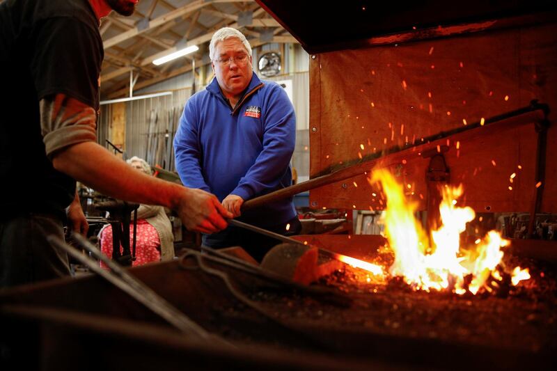 Republican senate nominee Patrick Morrisey watches as a forge is heated at blacksmith's in Falling Water, West Virginia. Reuters