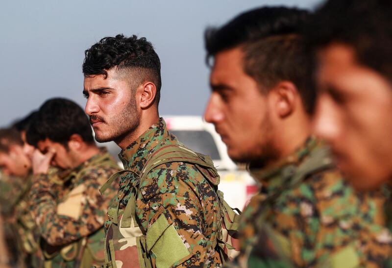 Arab fighters from the Syrian Democratic Forces (SDF) attend the fuenral an another Arab comrade in the town of Tal Tamr in the countryside of Syria's northeastern Hasakeh province on December 21, 2018, who was killed while fighting against the Islamic State (IS) group in Hajin in Deir Ezzor province.  / AFP / Delil SOULEIMAN

