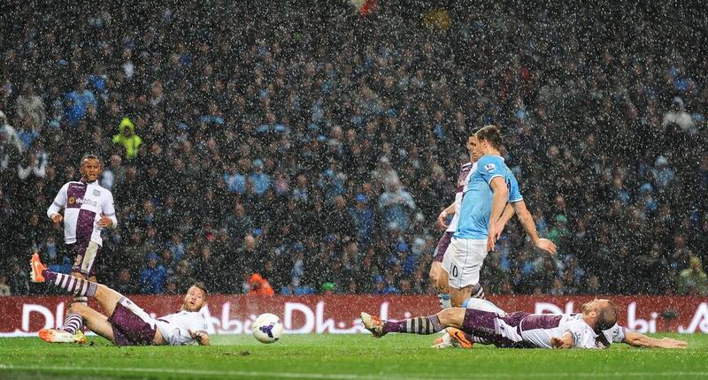Manchester City striker Edin Dzeko scores the opening goal against Aston Villa on Wednesday. Peter Powell / EPA / May 7, 2014