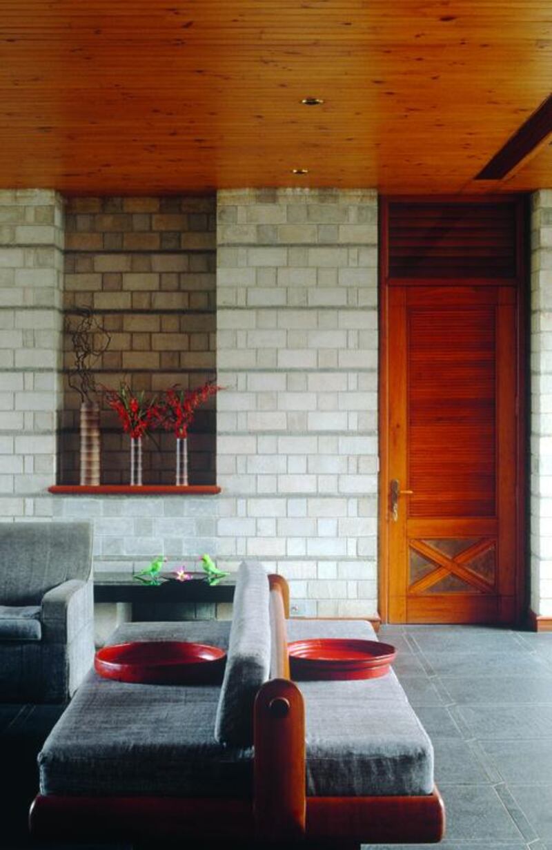 Grey seating ethnic styled siting room with tiled walls.