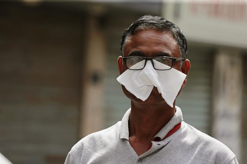 A man wears a piece of tissue to protect his face on a street in Manama. EPA